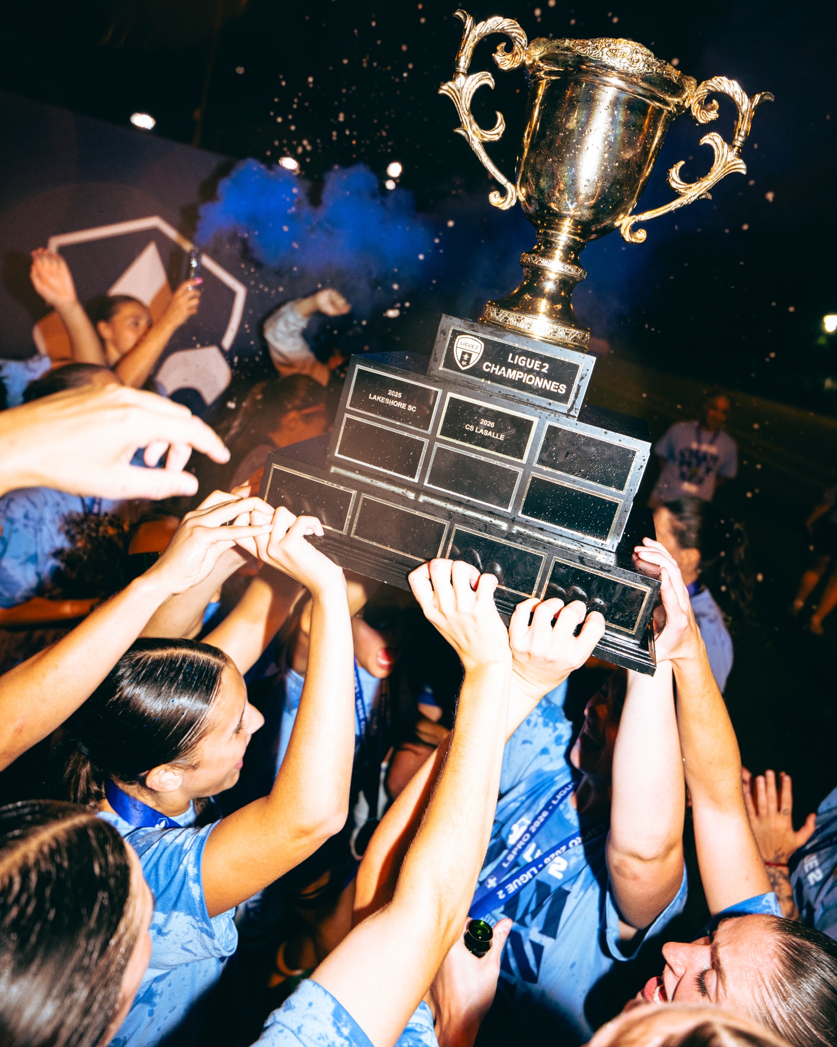 CS LaSalle players lifting the Ligue 2 championship trophy