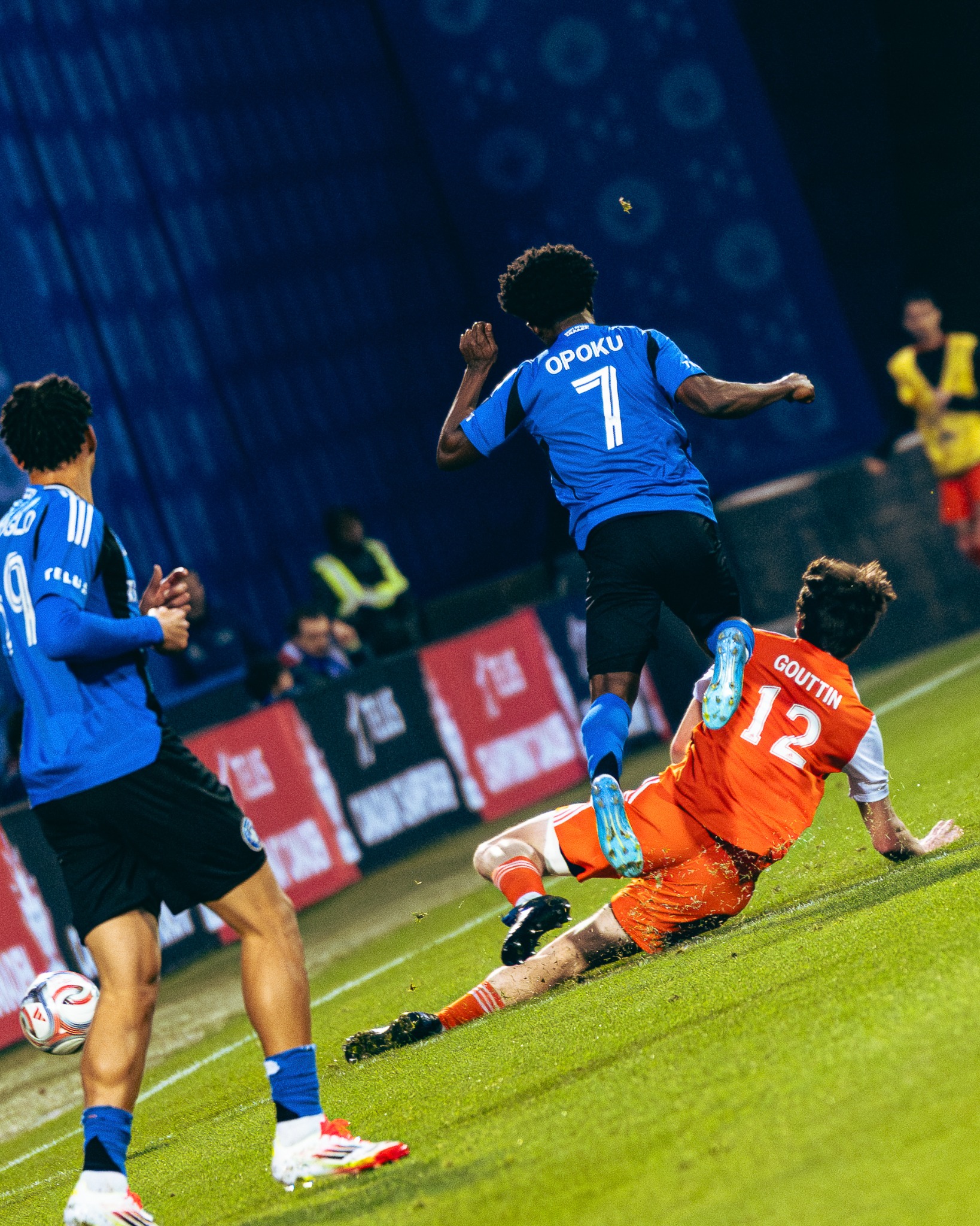 Goalkeeper rising above players during a night match in Montréal